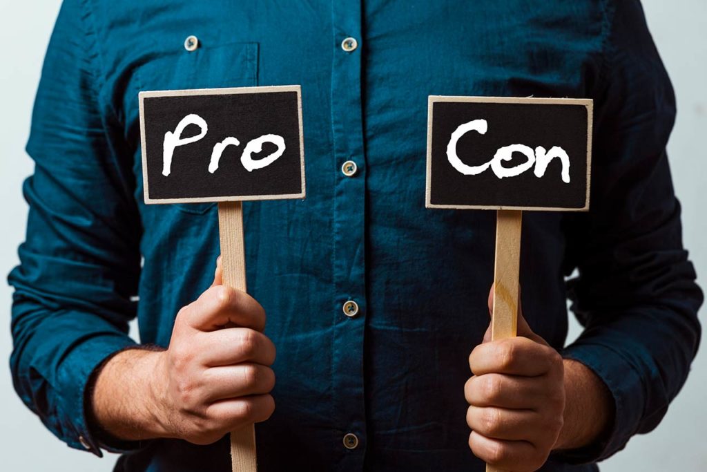 Photo of a man holding pros and cons cards